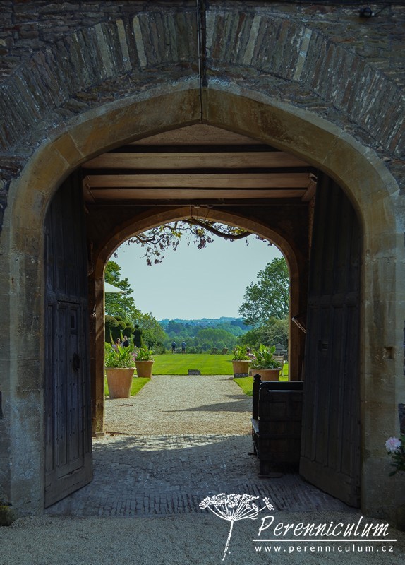 Zahrada v harmonii s okolní krajinou 1 Skrz otevřená vrata je vidět hlavní, reprezentativní část zahrady s širokým pásem trávníku, který jakoby přecházel volně do krajiny.