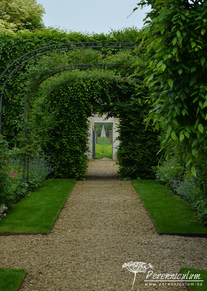 Příběh zahrady v Doyntonu 20 Z Růžové zahrady lze skrz dveře ve zdi walled garden vidět vzdálený kamenný obelisk.