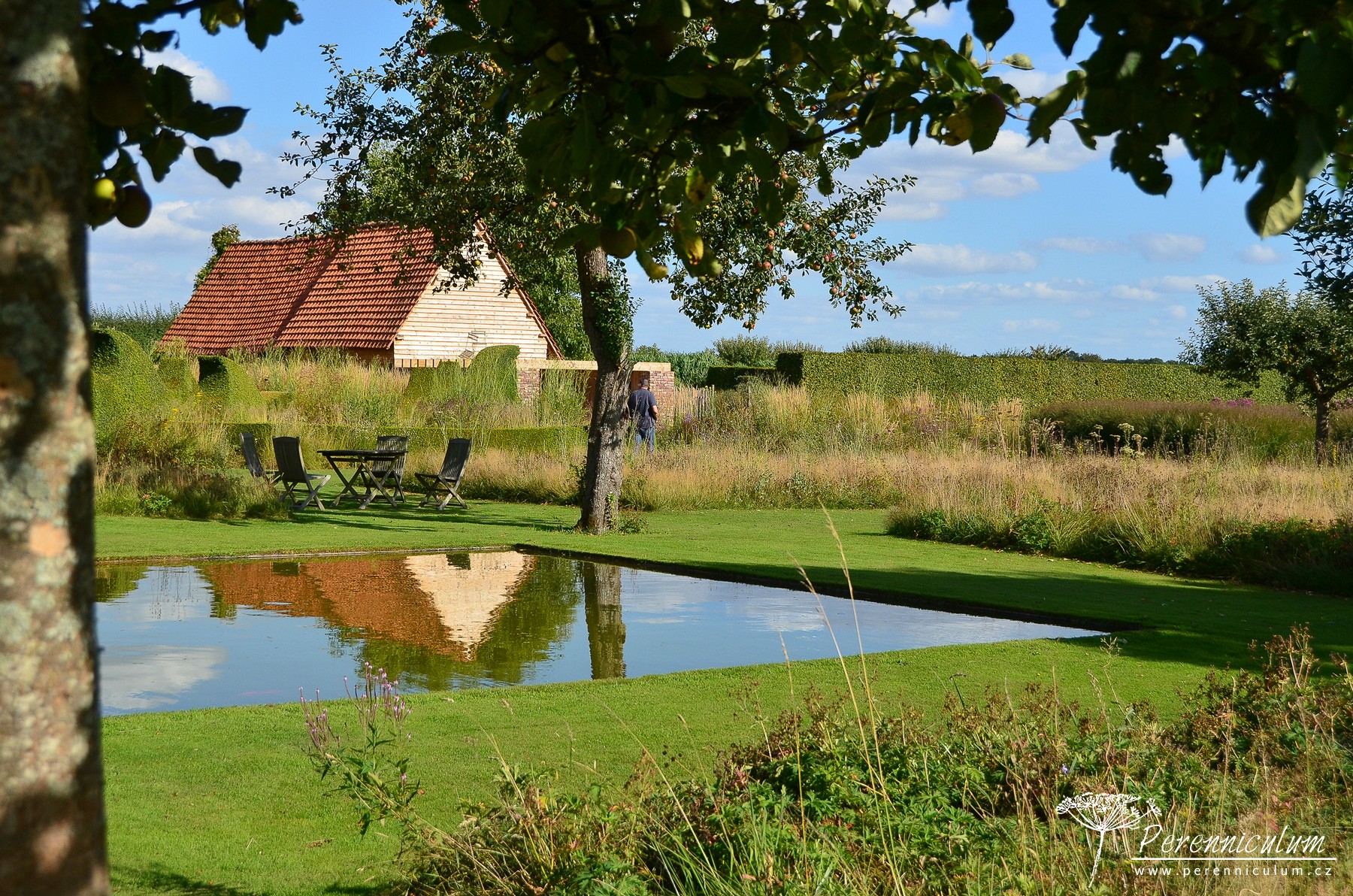 Le Jardin Plume - venkovské kouzlo s podtónem francouzské formální zahrady 22 Vodní hladina zrcadlí staré jabloně a rustikální budovy.